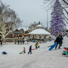 People enjoying a sledding hill in winter in downtown Leavenworth, Washington.
